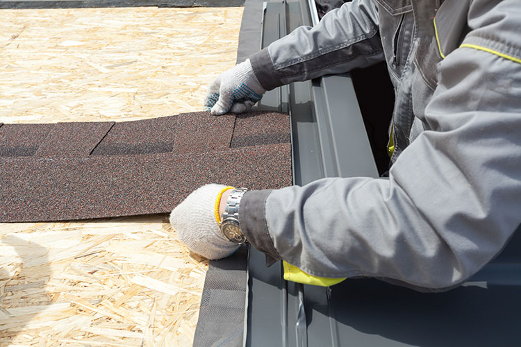 J&J Roofing & Construction contractor putting shingles on a roof.