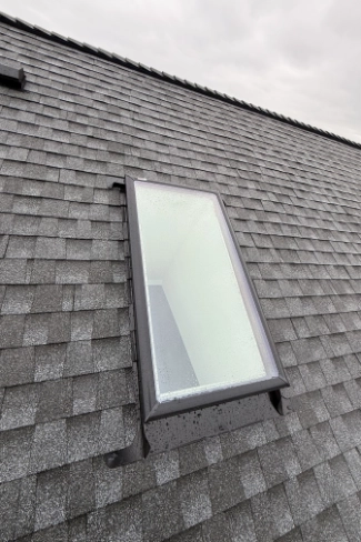 Crystal clear leak proof residential skylight replacement seamlessly integrated into a new asphalt shingle roof line on a home in the McLoughlin neighborhood