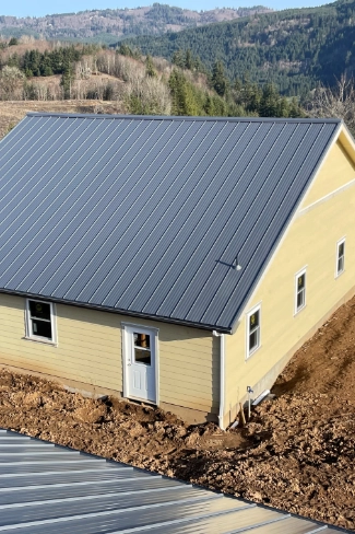 Finished commercial grade standing seam metal roof installation on a modern residential structure in the Lewelling neighborhood