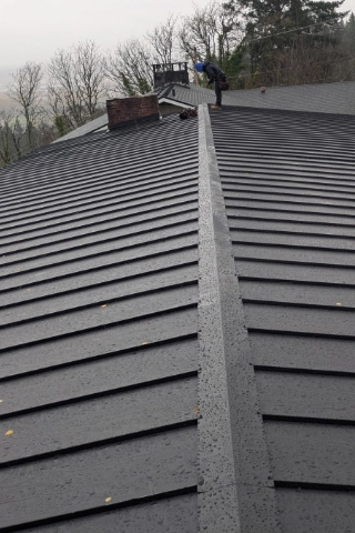 Clean lines of a finished commercial grade standing seam metal roof installation on a property near Charbonneau